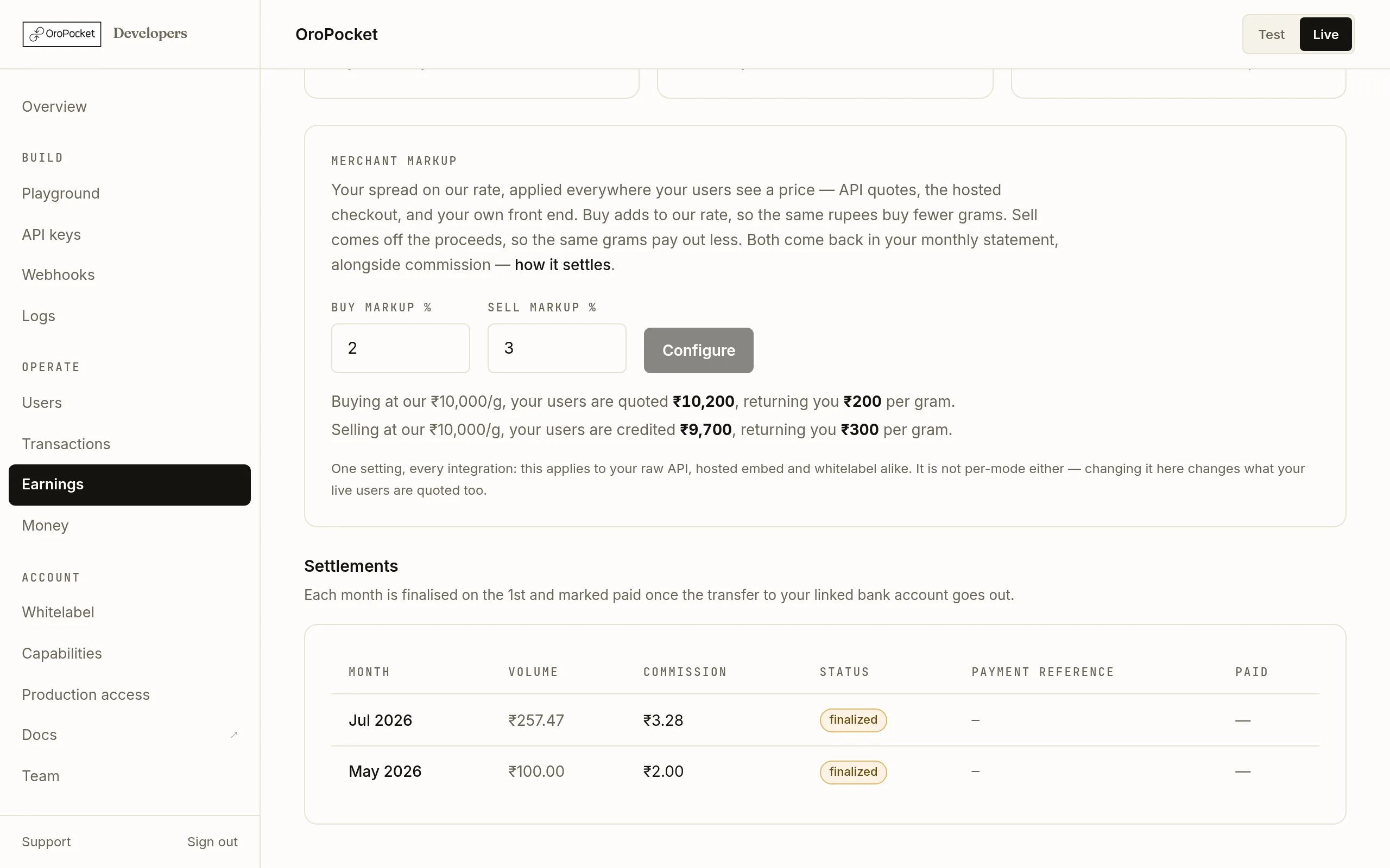 The Settlements table on the OroPocket Earnings page, with columns for month, volume, commission, status, payment reference and paid date.
